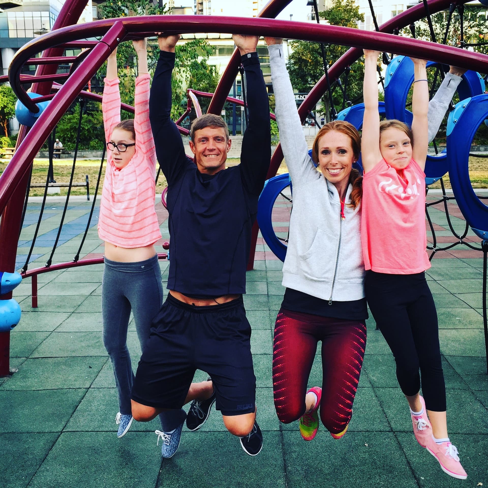 Dai Manuel with Christie and their daughters hanging from playground bars