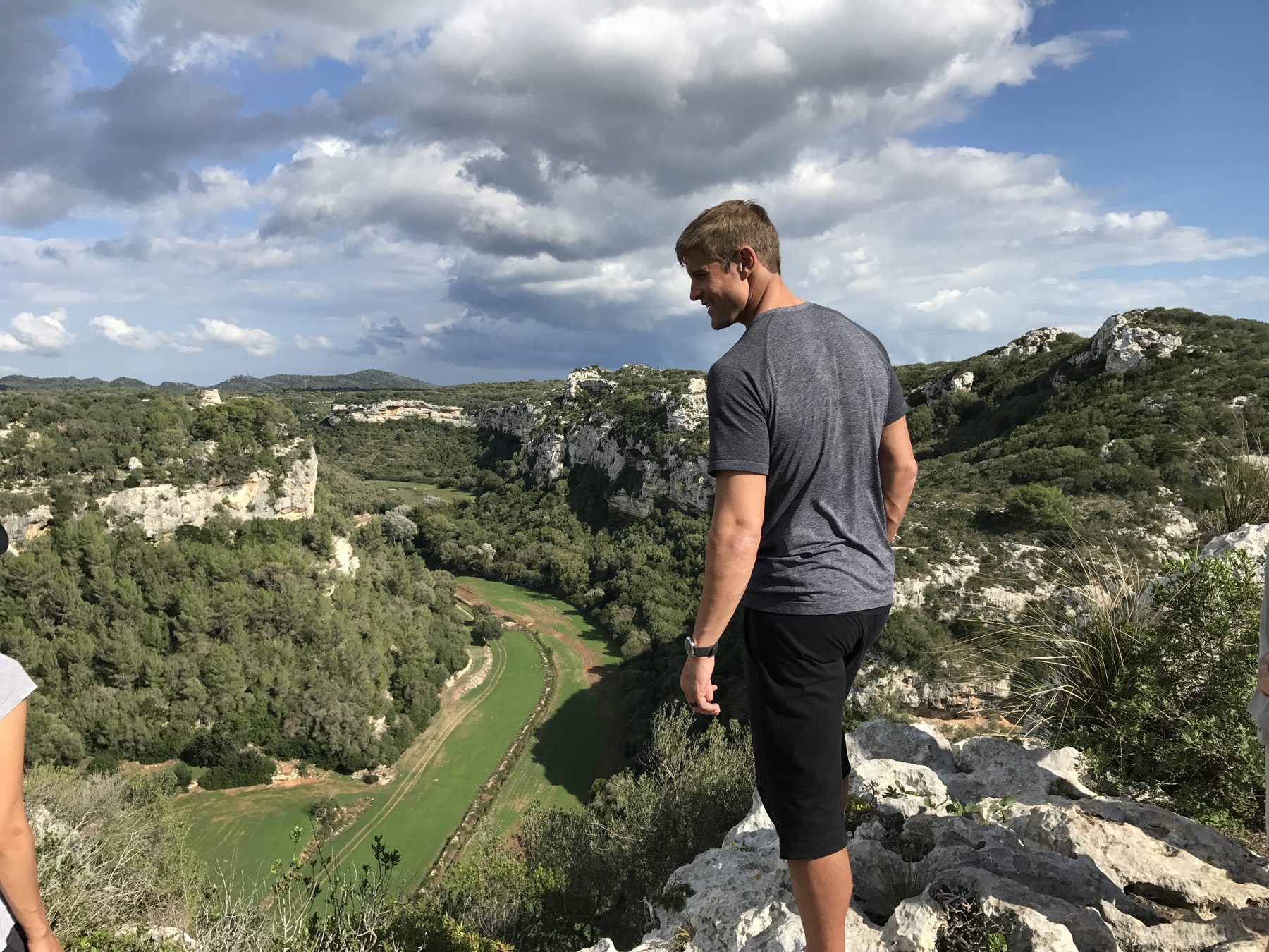 A man standing alone on a ridge looking out over a valley